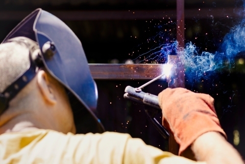 En mand der svejser i metal